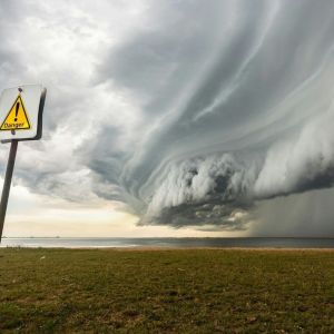 Symboliczna mapa nieba i fazy Księżyca na tle burzowych chmur – astrologia katastrof naturalnych